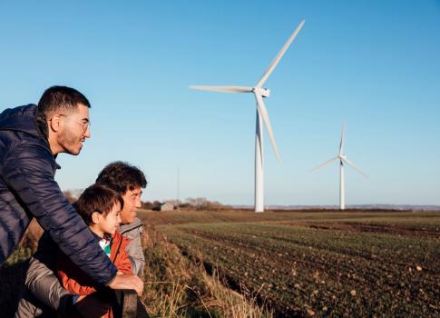 family looking out at windmill on a farm 